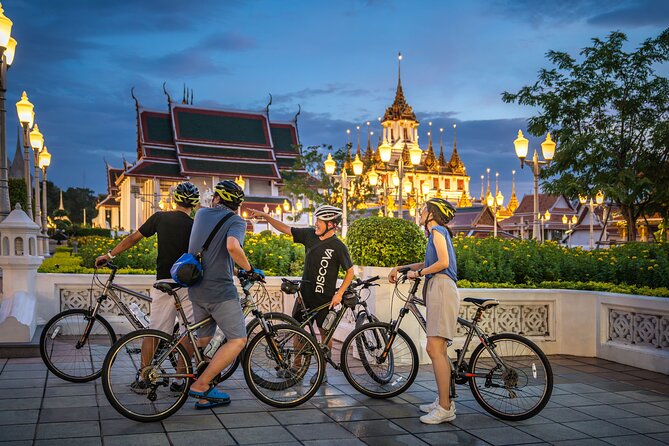 Bangkok: Night Bike Tour with Temples & Flower Market Visit - Wat Rakang and the glowing spires of Wat Arun