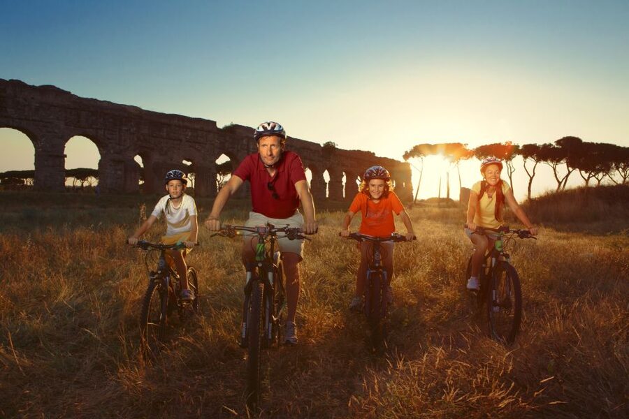Riders on the old Roman paving of the Appian Way at low sun
